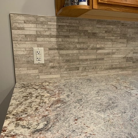 This next example consists of a limestone mosaic that combines brushed, hammered, and textured finishes in one backsplash.