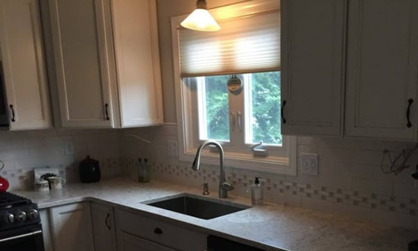 The decorative brick mosaic border extends around the entire kitchen.