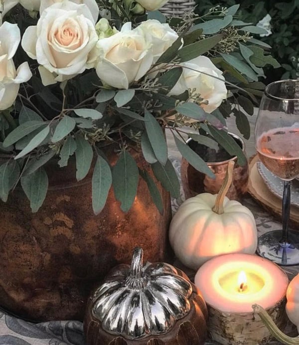 Consider using white roses as a live center piece to add glam to the table and visually transition from fall to winter