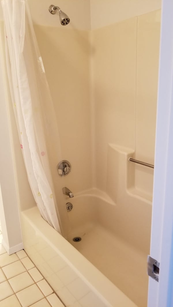 Drab 1980s condo shower