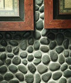 Closeup detail of sumatra black pebbles on a wall.