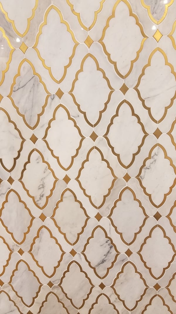 A diamond motif combined with an arabesque in a tile pattern that combines a marble look with yellow-gold