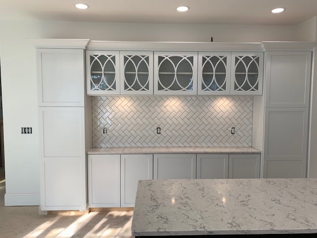 This installation of Q Premium Blanca Arabescato countertop with the white subway tile herringbone pattern and the fanciful cabinetry details make this space sing!